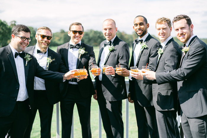 Groom getting ready with groomsmen and sipping cocktails