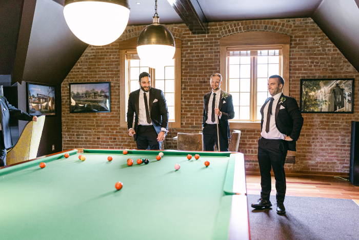 groomsmen playing pool before the wedding