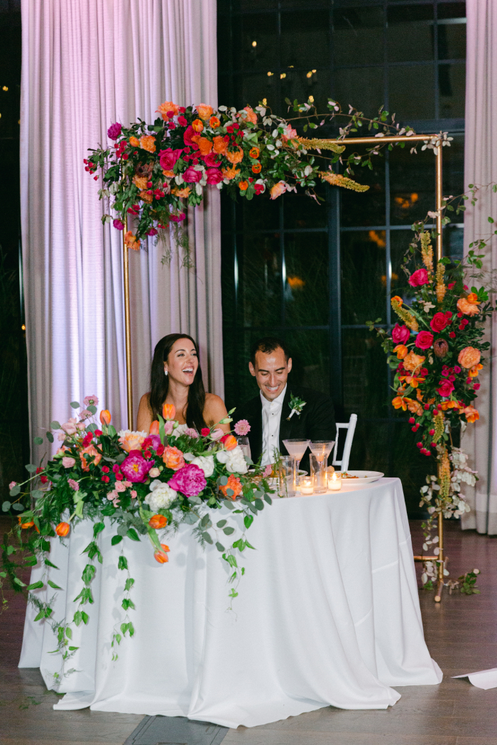 bride and groom sit at sweetheart table