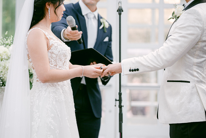Closeup of bride and groom exchanging rings during the ceremony