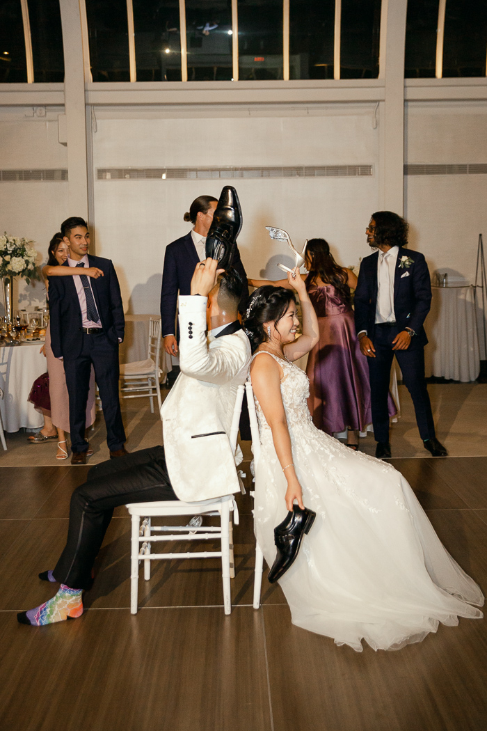 Bride and groom play shoe game at elegant black tie NYC wedding
