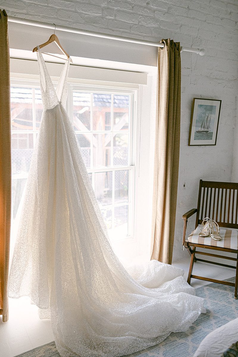 BRIDES GOWN HANGING UP IN WINDOW 