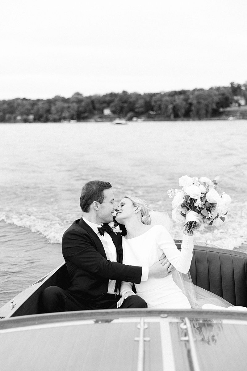 BRIDE AND GROOM ON BOAT LEAVING WEDDING CEREMONY AT INNS OF AURORA 