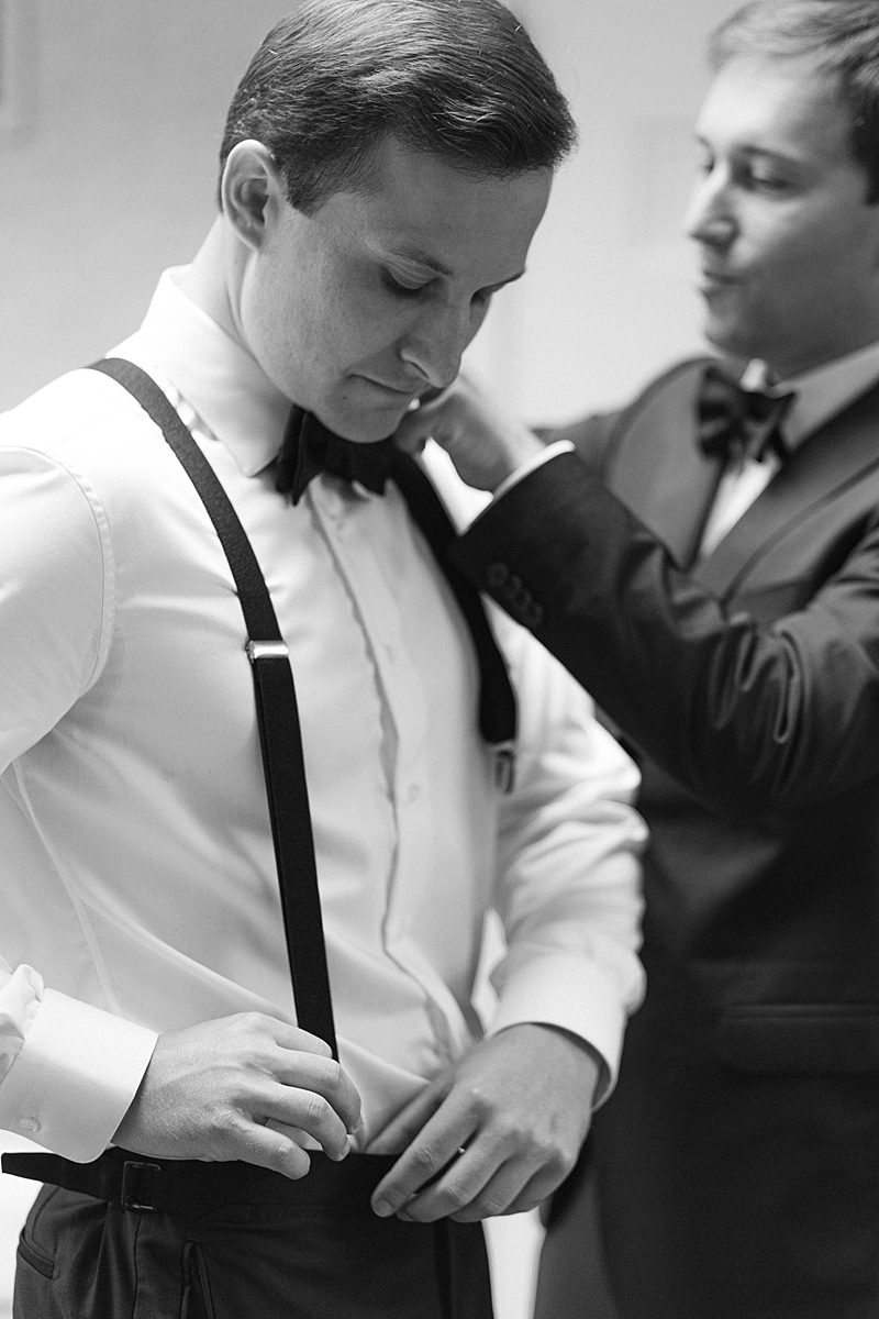 BLACK AND WHITE PHOTO OF GROOM GETTING READY